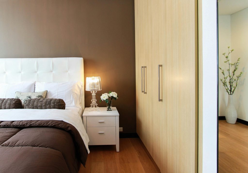 Dormitorio con cama tapizada, mesita de noche y armario